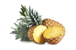 Ananas intero e affettato su sfondo bianco, fresco e succoso